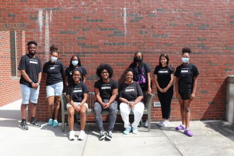 The James Cates Scholars pose for a photo outside the library.